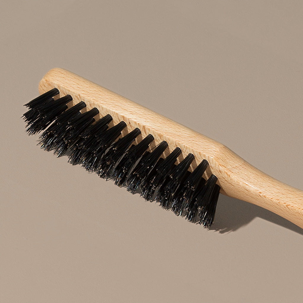 Details Close up of Groom black boar bristles beard or hair brush with idled clear beech wood handle