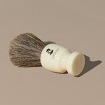 Groom shaving brush with brown horsehair bristles and cream off white acetate handle with black mustache man logo