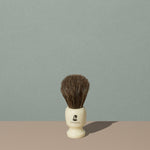 Groom shaving brush with brown horsehair bristles and cream off white acetate handle with black mustache man logo