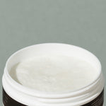 View inside creamy white Groom shaving cream in a round white plastic container packaging with a white and black label with a mustache man logo