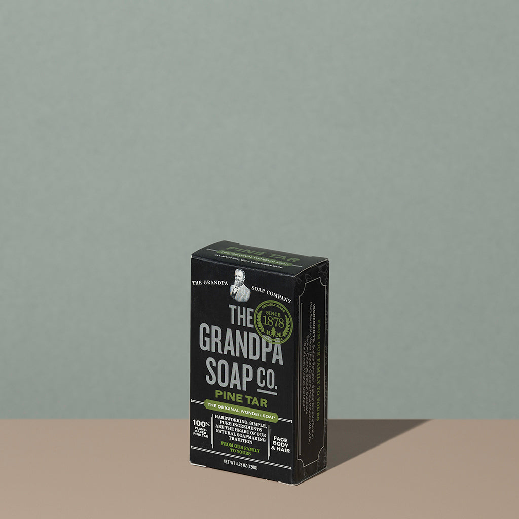 The Grandpa soap Co Pine tar soap bar in a square rectangle black cardboard packaging with white and green writings