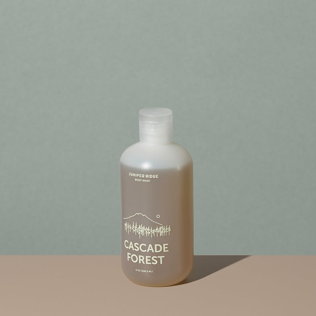 Juniper Ridge cascade forest body wash in an all clear cylindric plastic bottle with a flip top dispenser cap and white labelling of mountain and brand name