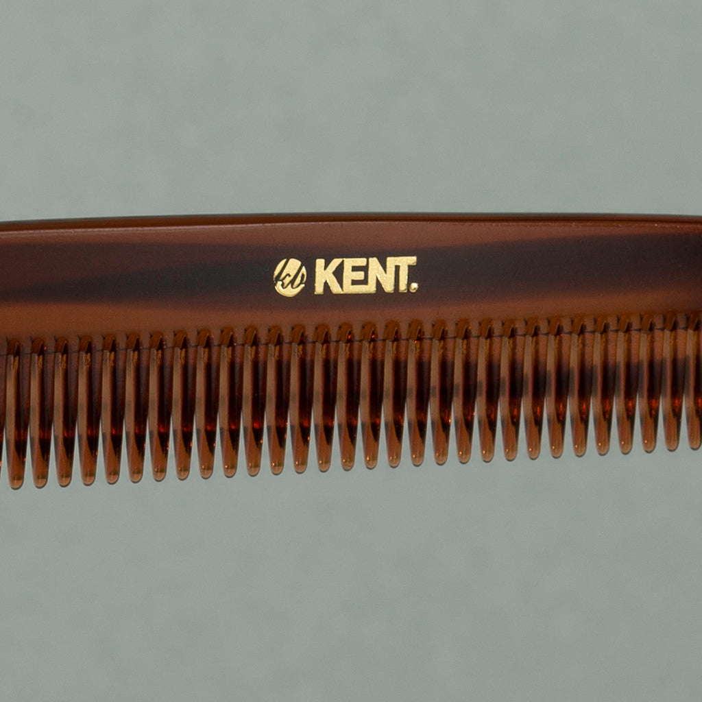 Close up details of tortoise Kent large coarse handcrafted 190mm acetate rounded tooth comb for hair or beard on a table