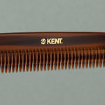 Close up details of tortoise Kent large coarse handcrafted 190mm acetate rounded tooth comb for hair or beard on a table