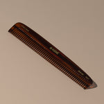 Kent tortoise large coarse handcrafted acetate rounded tooth comb for hair or beard with gold label on a table
