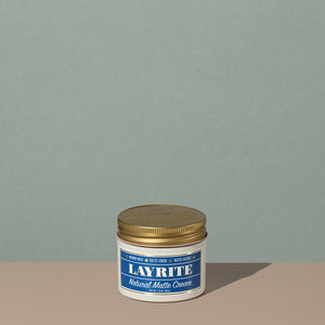 Layrite 4.25oz Natural Matte Cream Medium Hold & Natural Finish hair pomade in a rounded white plastic container with gold twist cap and blue label