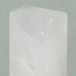 Close up of details of Osma bloc d'alun out of the packaging is a white see through rectangle salt stone