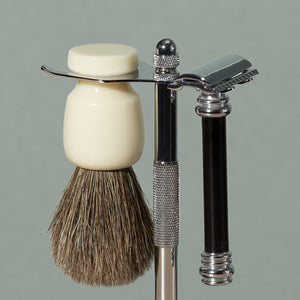 Close up on pure badger shaving cream Badger brush and black safety razor stand in chrome stainless steel