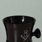 Close up detail of Pure badger shaving porcelain shaving mug with handle in black with a white logo