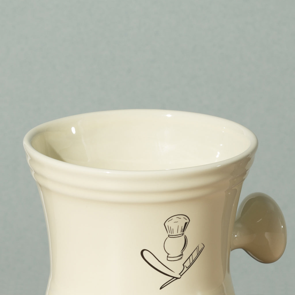 Close up detail of Pure badger shaving porcelain shaving mug with handle in cream with a silver logo