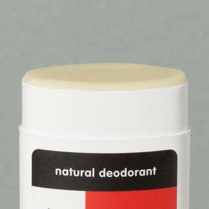 Close up details of creamy wax Thinksport natural deodorant in a white typical rounded square deodorant plastic container with red, black and white logo sticker and a cap