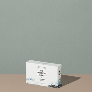 The Unscented Company biodegradable Soap Bar in a white cardboard rectangular packaging with black writings and foggy gray mountains