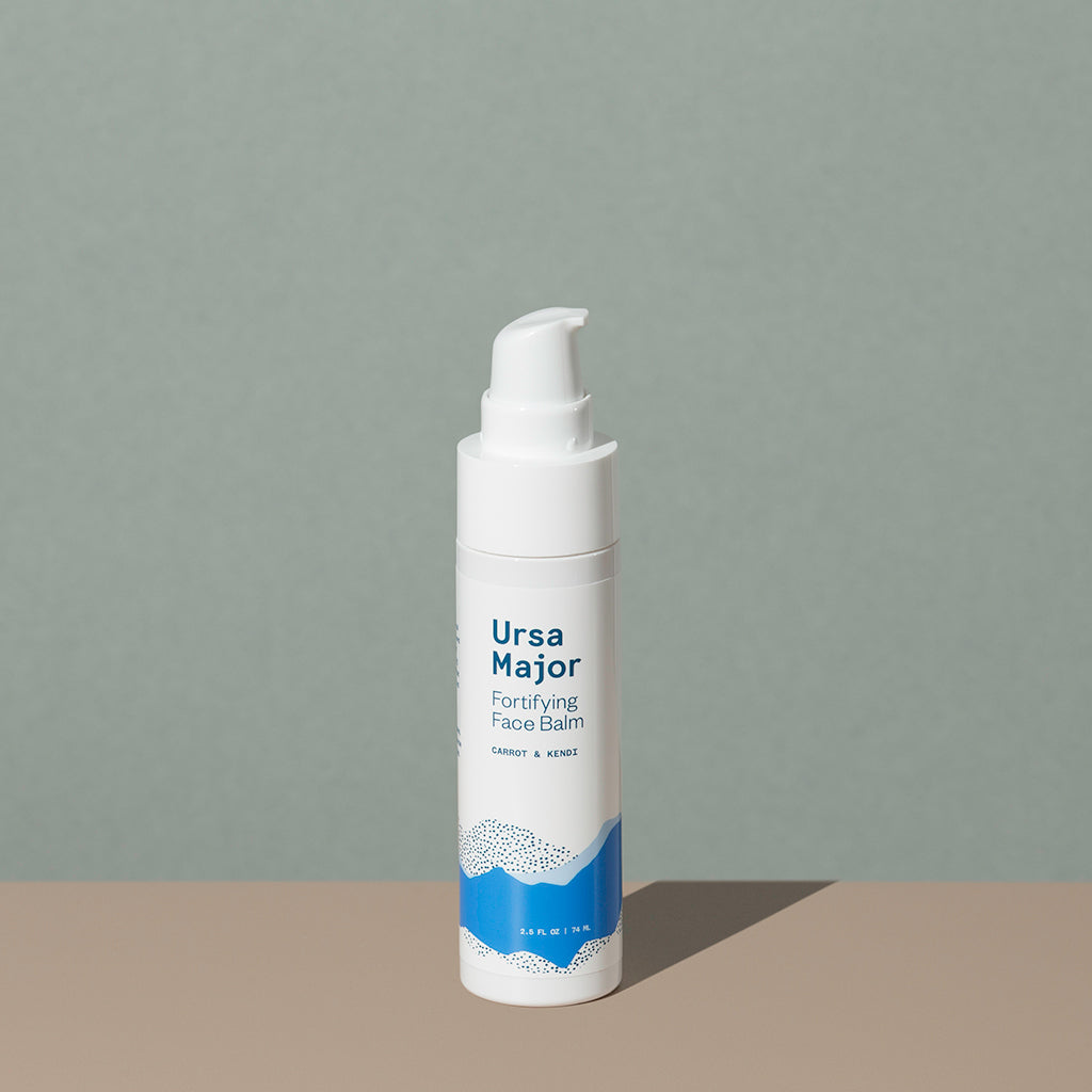 Ursa Major Fortifying Face Balm in a small white cylindric plastic bottle with a press down dispenser cap and a blue labeling of mountains