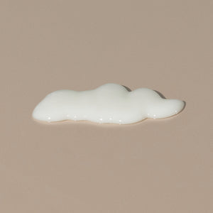 Ursa Major Go Easy hair Conditioner spread of a white cream texture on a table