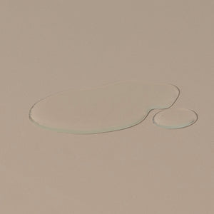 Texture of Ursa Major Go Easy hair Shampoo transparent liquid spread on a table